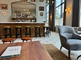 The Five of Clubs lounge has a handsome full bar backed by a mirror and varied seating.