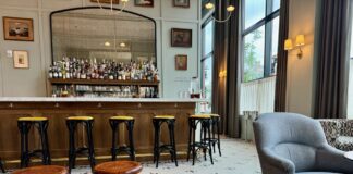 The Five of Clubs lounge has a handsome full bar backed by a mirror and varied seating.