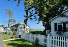 White cottages behind picket fences have views to the ocean.